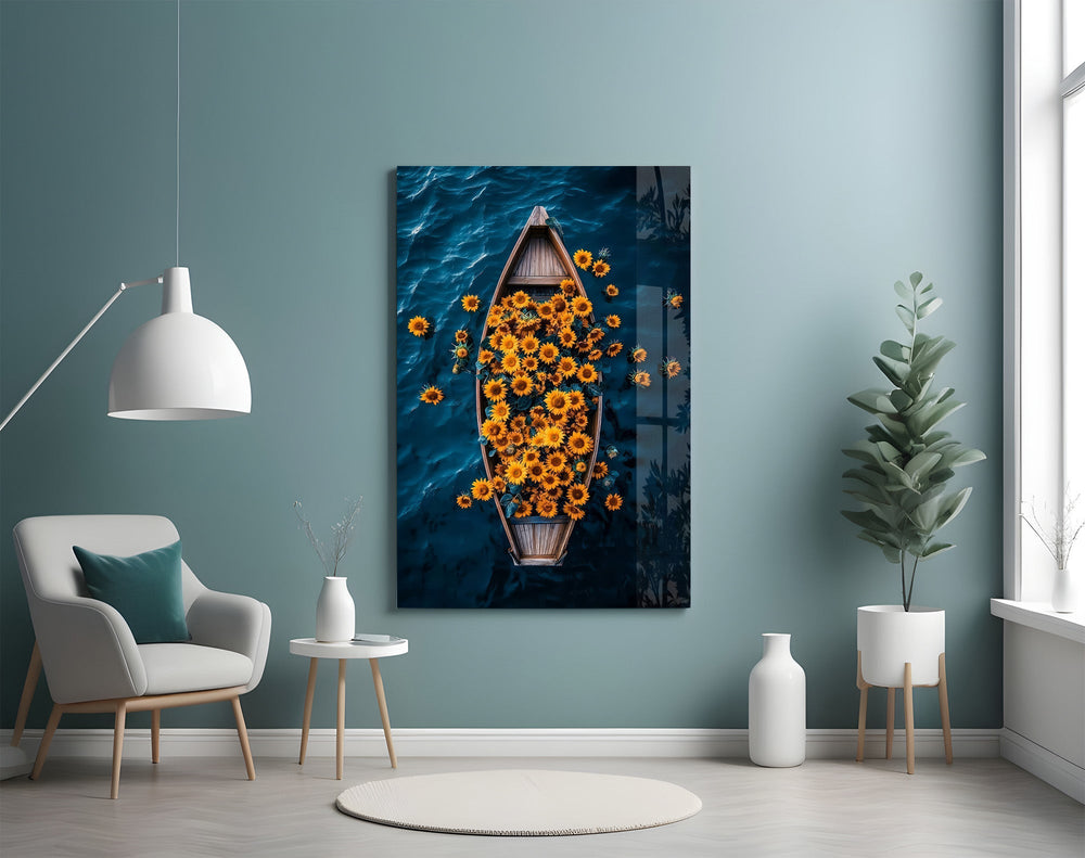 a wooden rowboat full of sunflowers on dark water glass wall art styled above an armchair in a reading corner