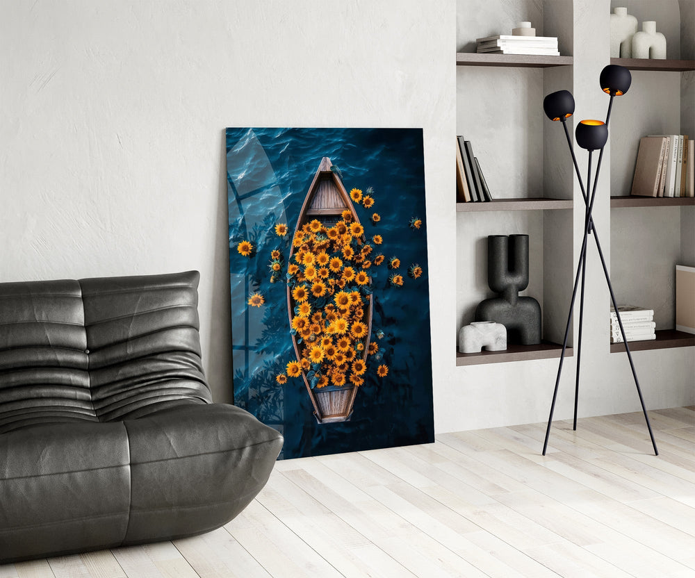 a wooden rowboat full of sunflowers on dark water glass wall art leaning beside a dark leather sofa
