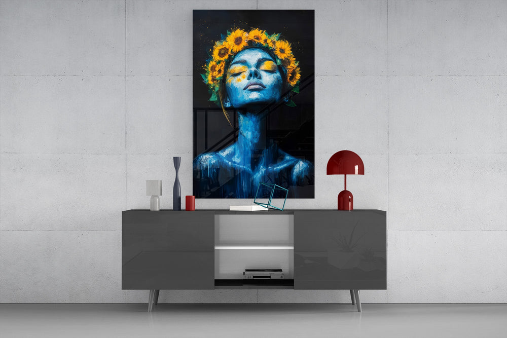 a blue-skinned woman crowned with sunflowers glass wall art styled in an atmospheric room setting