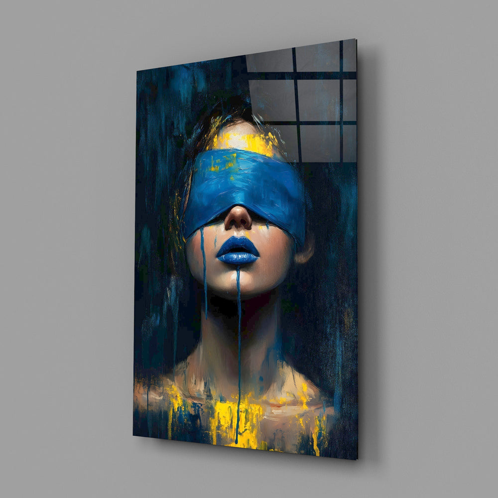 a blindfolded woman with blue lips and dripping paint glass wall art angled to show the polished tempered glass panel