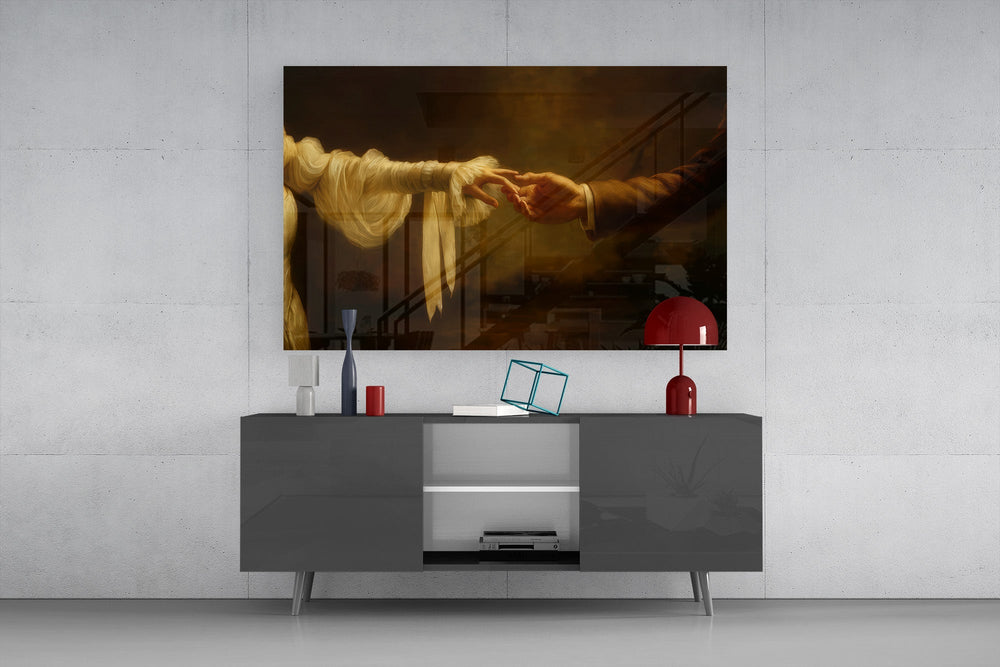 two hands reaching in golden light glass wall art styled in an atmospheric room setting