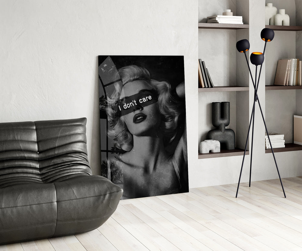 vintage blonde bombshell portrait glass wall art leaning beside a dark leather sofa
