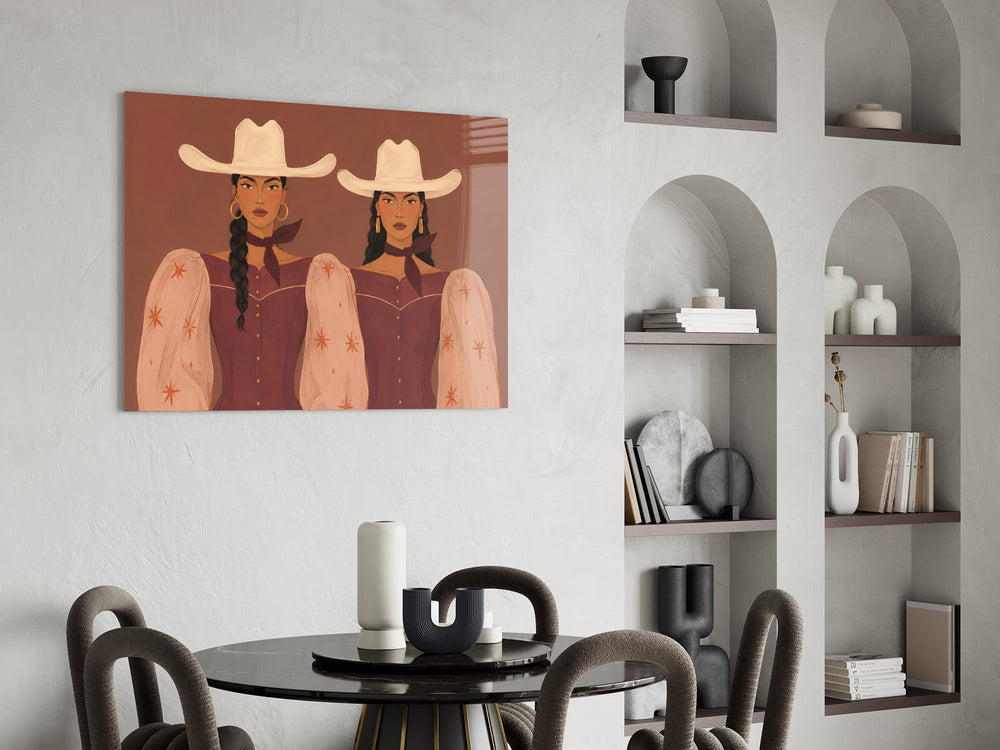 two cowgirls in matching western dresses glass wall art leaning beside a dark leather sofa