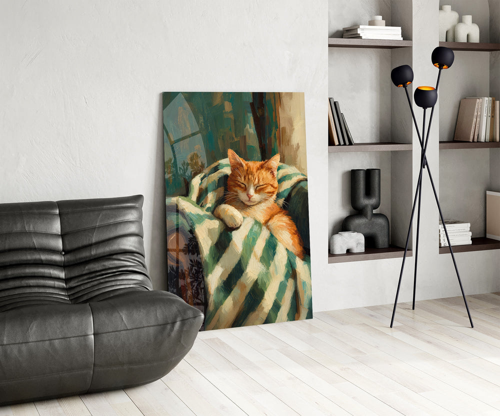 sleeping ginger cat in a striped blanket glass wall art leaning beside a dark leather sofa