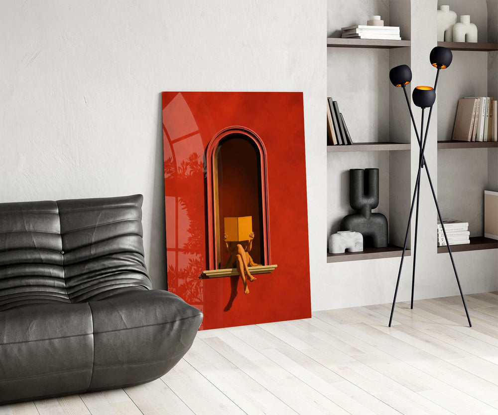figure reading in a red arched niche glass wall art leaning beside a dark leather sofa