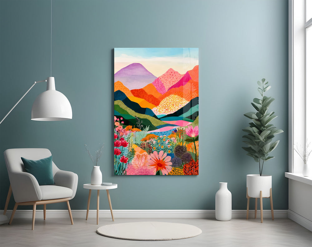 colorful layered mountains above a flower valley glass wall art styled above an armchair in a reading corner