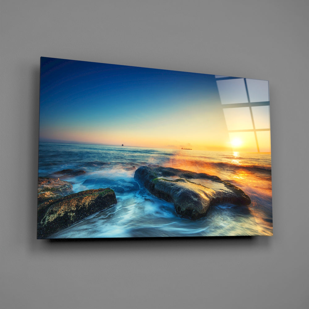 Close-up detail of wet rocks and silky turquoise surf at sunrise