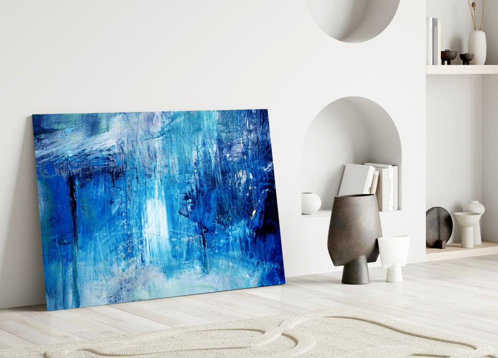 Abstract glass wall art styled above a bed in a serene blue bedroom