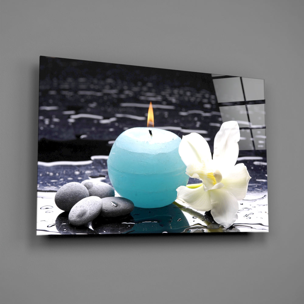 Close-up detail of turquoise candle, white orchid, and spa stones