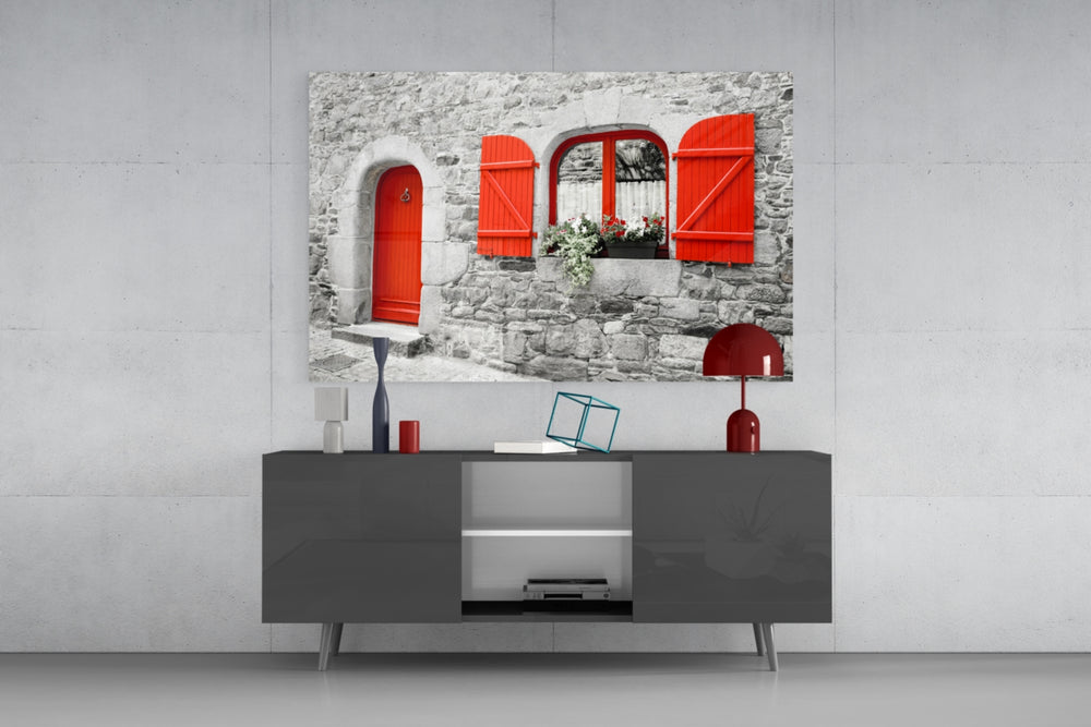Fine art photography – vivid red door and wooden shutters with flower box on traditional stone building, selective color style