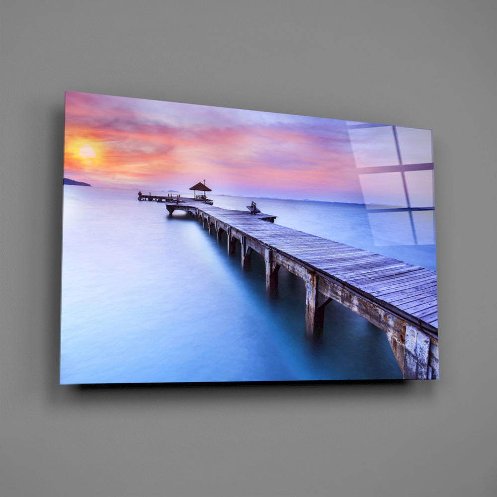 Close-up detail of the wooden jetty stretching into a rose and amber sunset