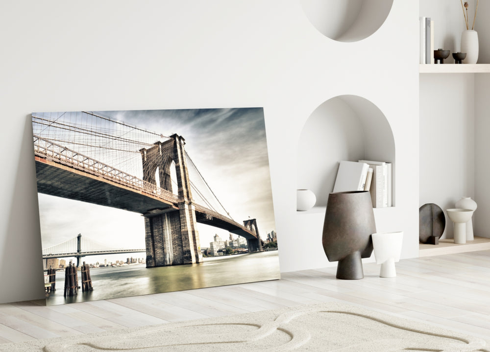 Brooklyn Bridge glass wall art styled above a sofa in a literary living room