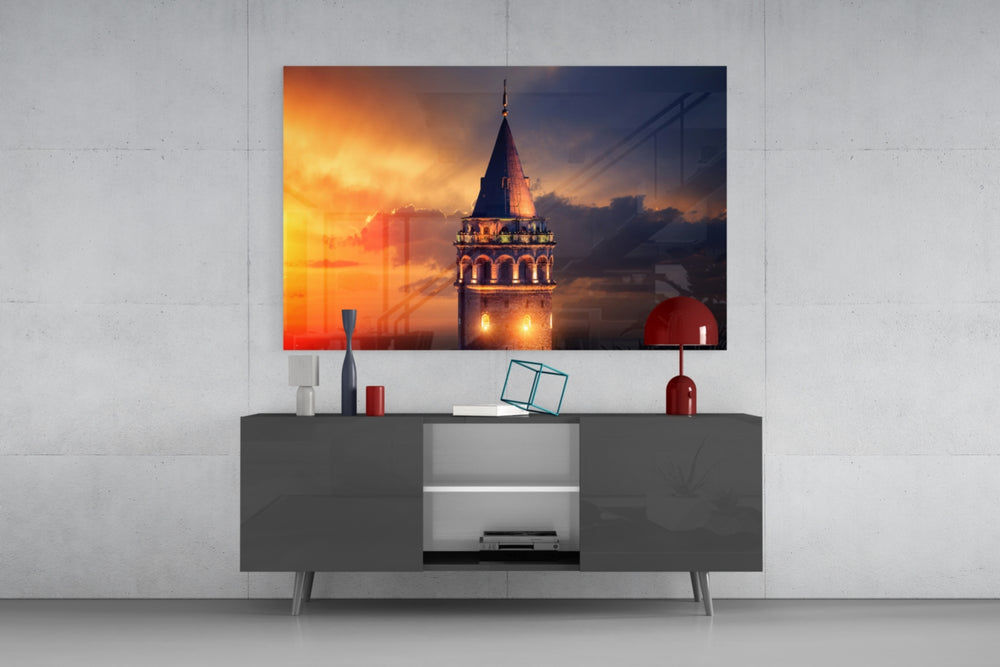 Fine art architecture photography – historic Galata Tower with lit arched windows rising against vivid orange and deep indigo stormy sky