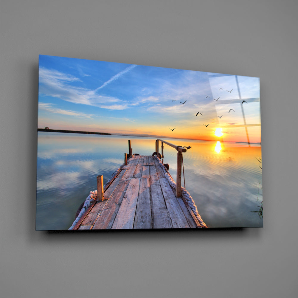 Close-up detail of the wooden dock with birds rising at sunrise