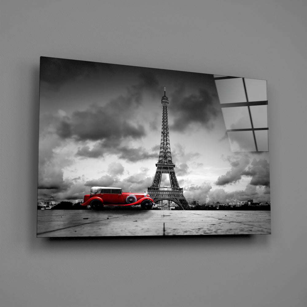 Close-up detail of the red vintage car against a grayscale Eiffel Tower