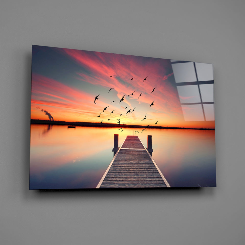Close-up detail of the dock and birds against a fiery reflected sunset