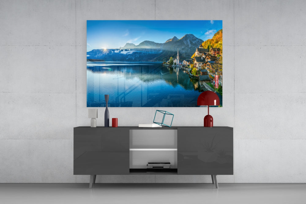 Fine art photography – Hallstatt village with pastel facades and alpine church perfectly reflected in still lake, dramatic mountain backdrop