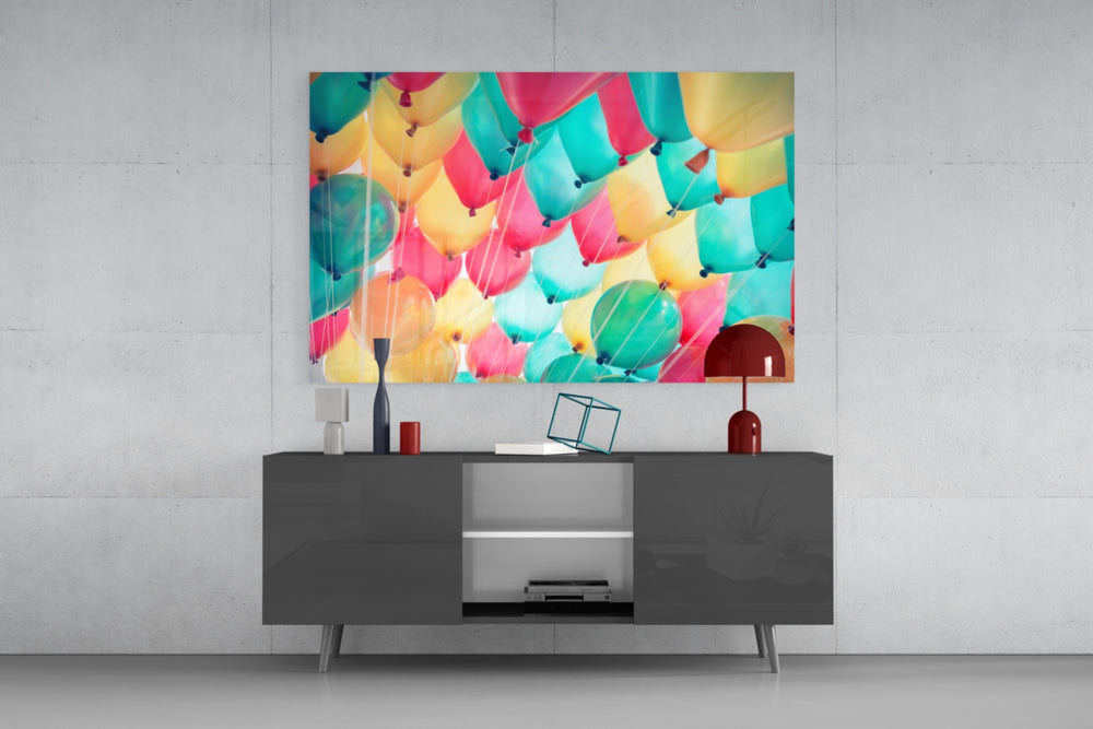 Fine art photography – close arrangement of pastel balloons in pink, mint green, yellow and ivory, strings trailing, viewed from below