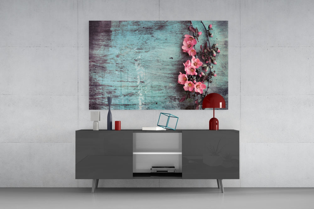 Fine art photography – delicate pink spring flowers on branch resting against weathered teal painted wood with natural grain texture