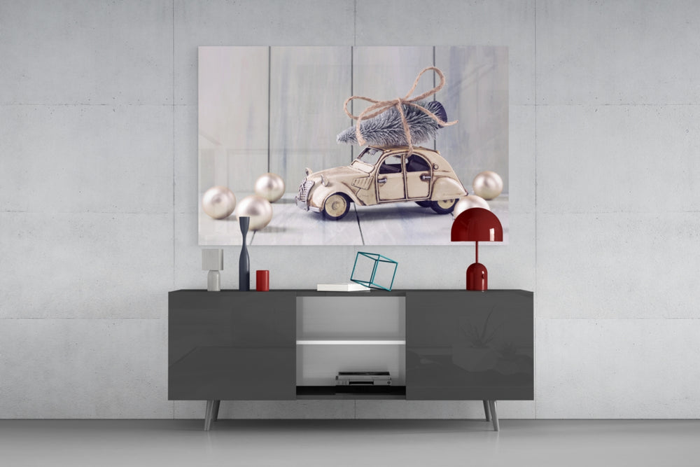 Fine art still life – vintage cream toy Citroën 2CV with miniature Christmas tree and twine bow on roof, pearl ornaments on wood plank surface