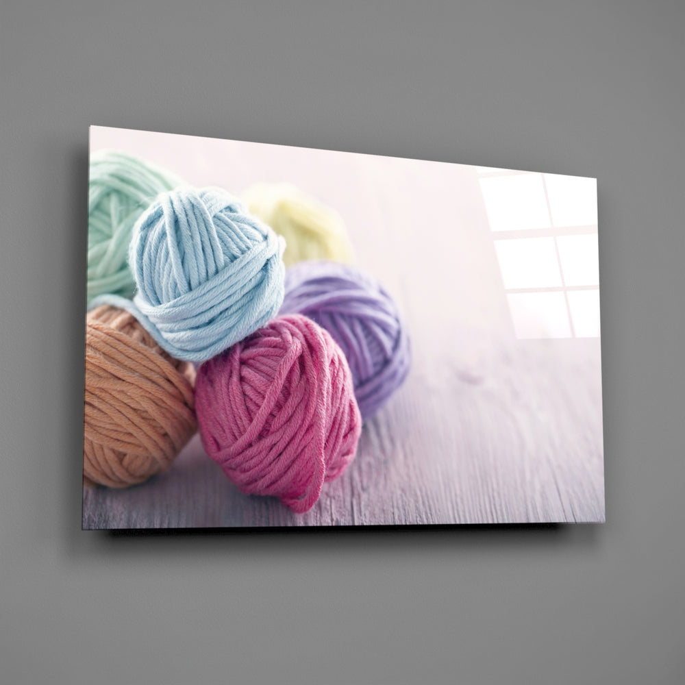 Close-up detail of pastel yarn balls on whitewashed wood