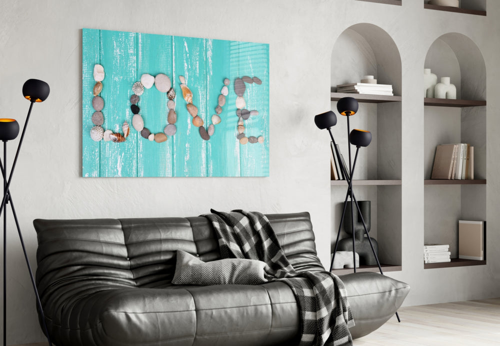 Love glass wall art styled above a bed in a couple's bedroom