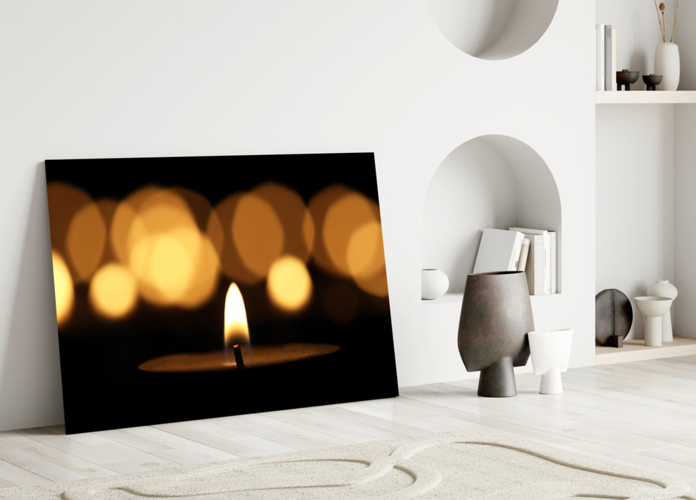 Close-up detail of the single flame with warm gold bokeh