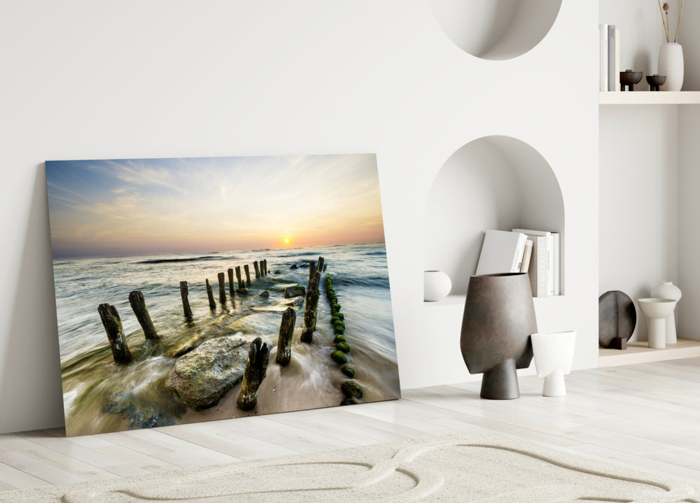 Close-up detail of the moss-covered groyne posts in the sunset surf