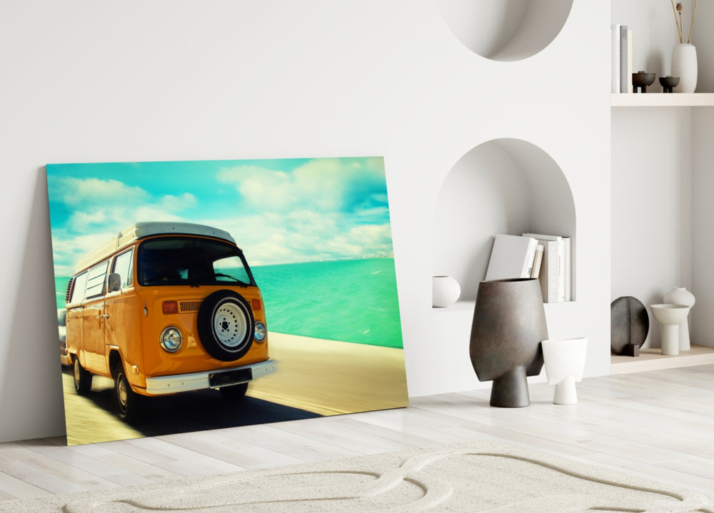 Close-up detail of the orange VW bus against turquoise sea