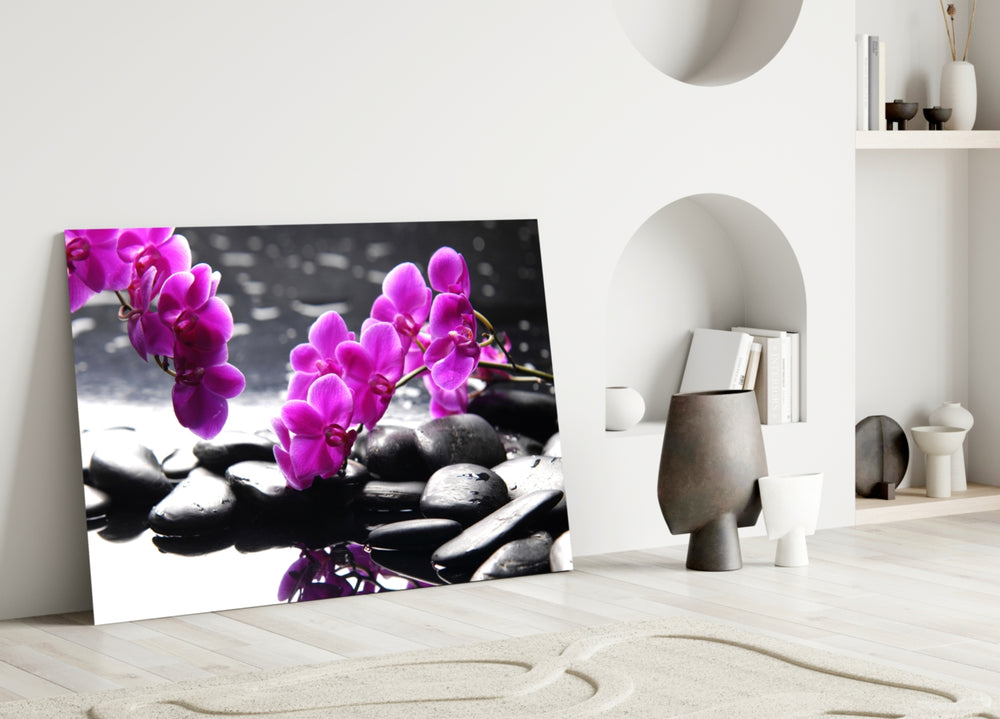 Close-up detail of the magenta orchid spray on wet stones