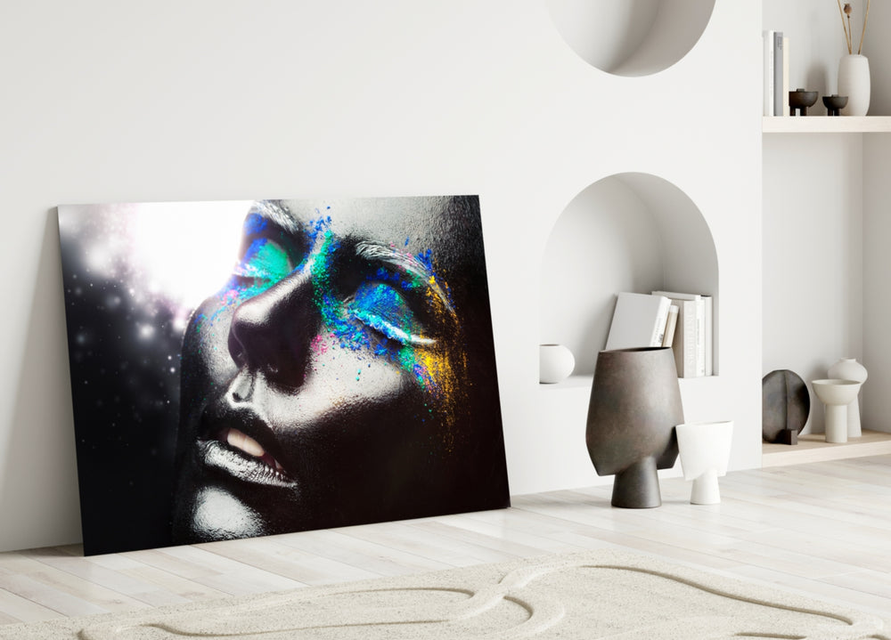 Close-up detail of cobalt, jade and magenta pigment across closed eyes