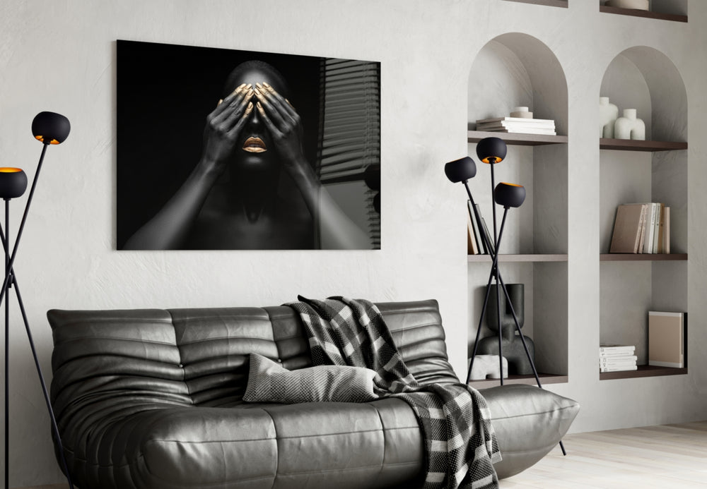 Woman glass wall art styled above a bed in a black-and-gold bedroom