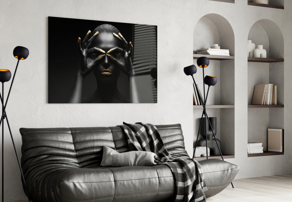 Woman glass wall art styled above a bed in a black-and-gold bedroom