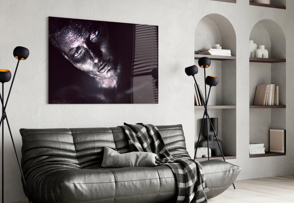 Woman glass wall art styled above a bed in an after-dark bedroom