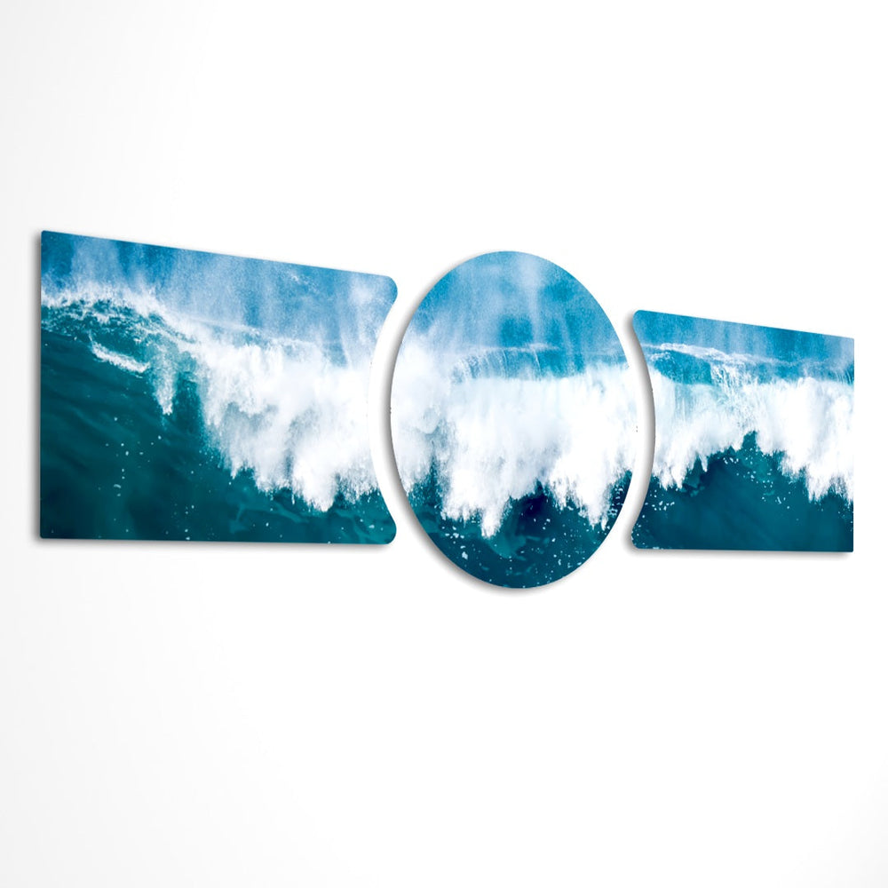 A powerful ocean wave breaking into white foam and spray across deep blue and teal water under a soft sky 3 piece glass wall art set E