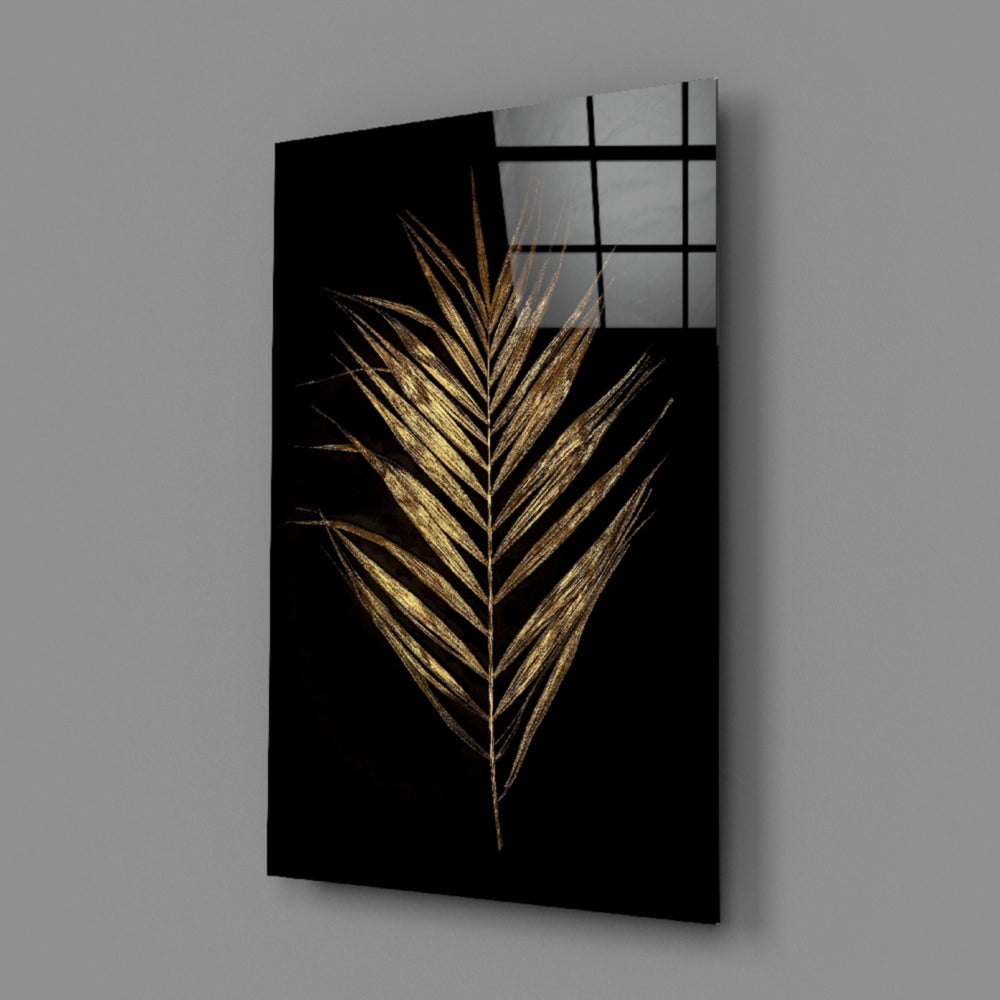 Close-up detail of single gold palm frond against velvet black