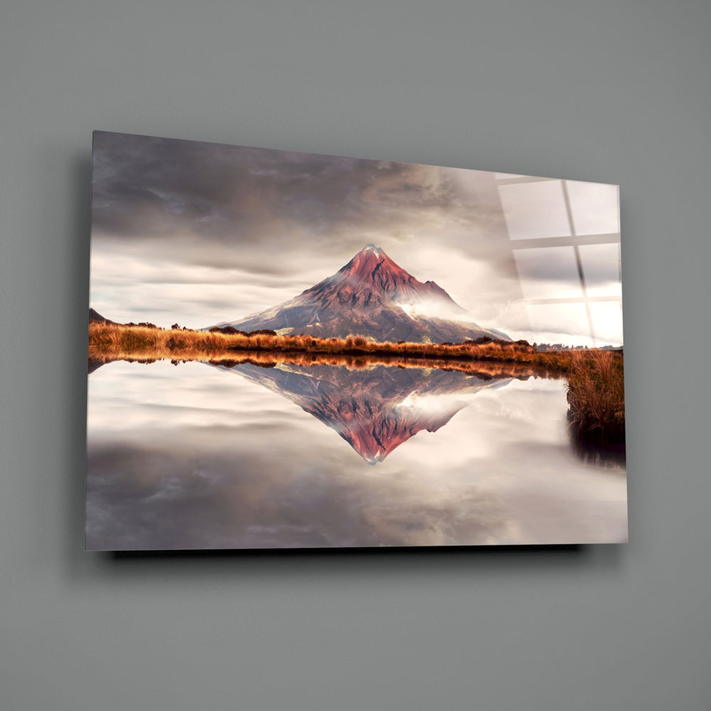 Mountain close-up showing rust-red volcanic peak mirrored on still water