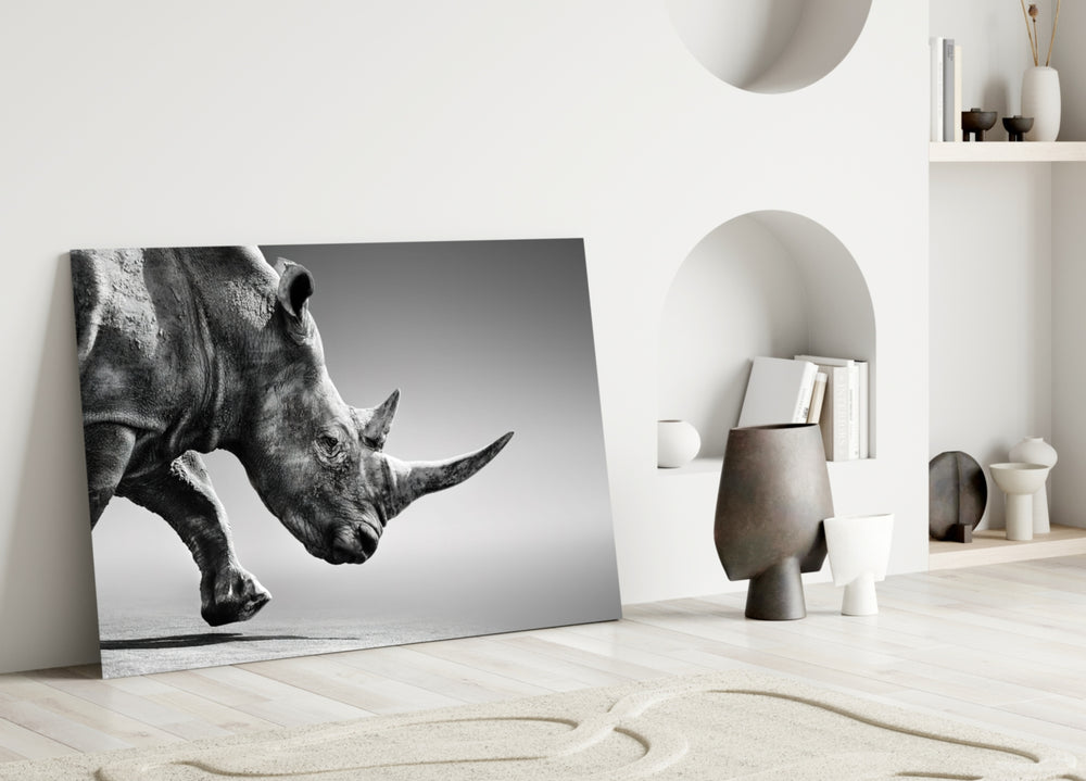Black Rhino glass wall art styled above a console in a living room