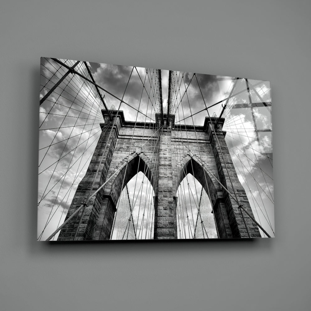 Brooklyn Bridge close-up showing Gothic arches and suspension cables under cloudy sky