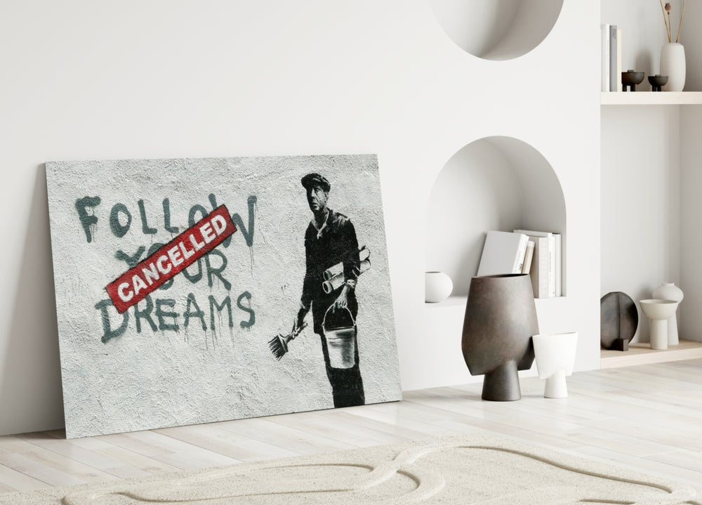Plans Cancelled close-up showing painter beside Follow Your Dreams Cancelled red stamp