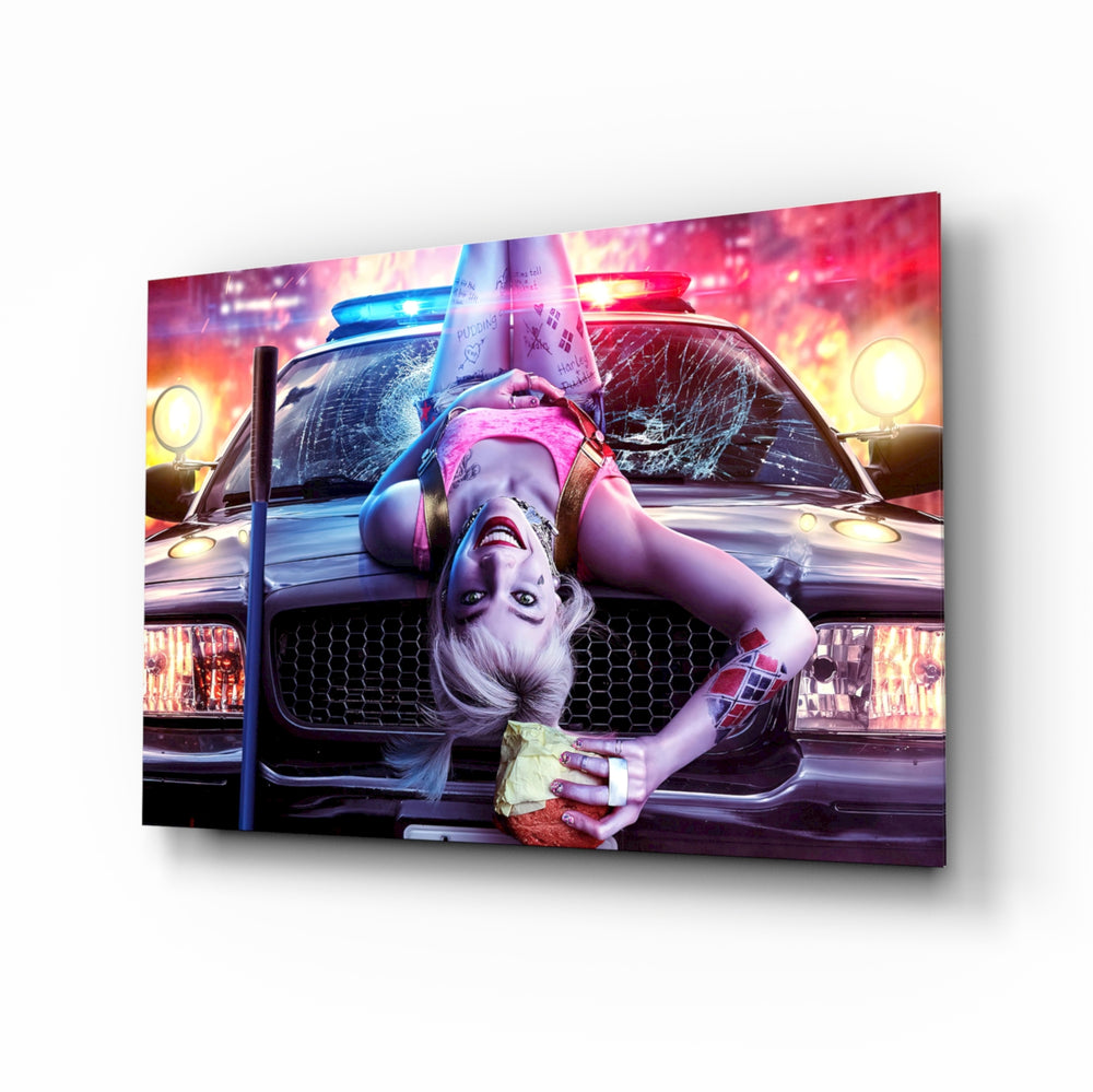Harley Quinn glass wall art displayed above a black gaming sofa in a neon-lit gaming room with RGB chair and matte-black shelves