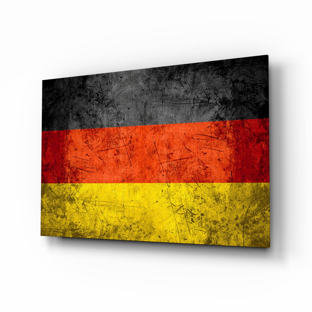 Flag of Germany glass wall art displayed above a leather chesterfield in a brick-walled man cave with reclaimed-wood console and matte-black floor lamp