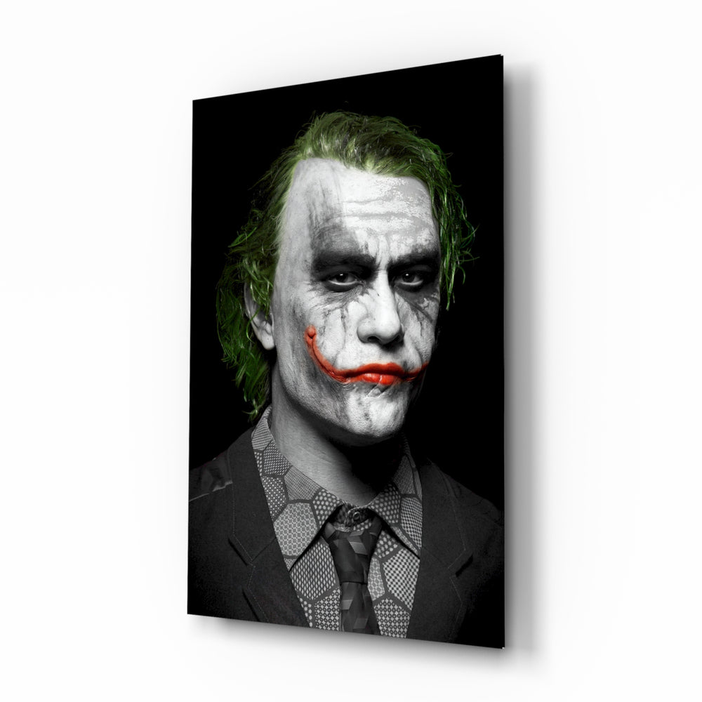Joker glass wall art displayed above a black leather sofa in a moody home theater with brass arc lamp and reclaimed-wood console