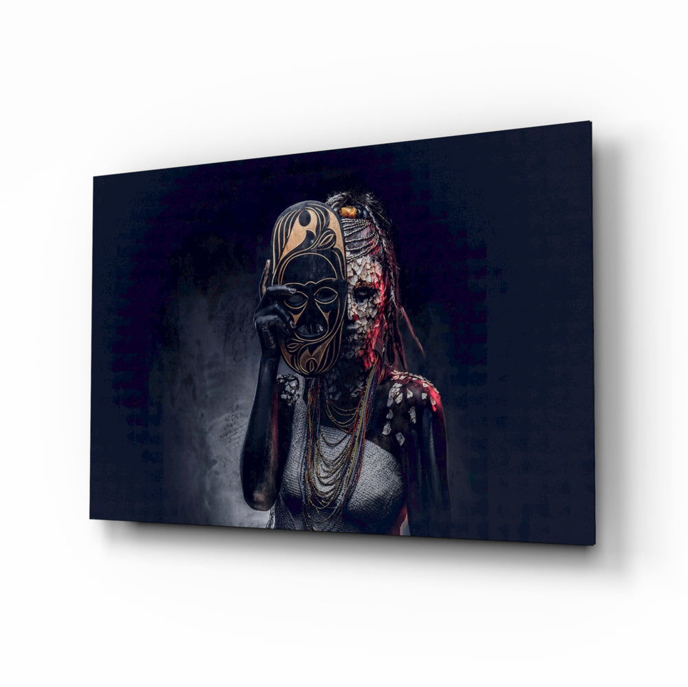 Behind the Mask glass wall art displayed above a black leather sofa in a moody lounge with reclaimed-wood console and brass arc lamp