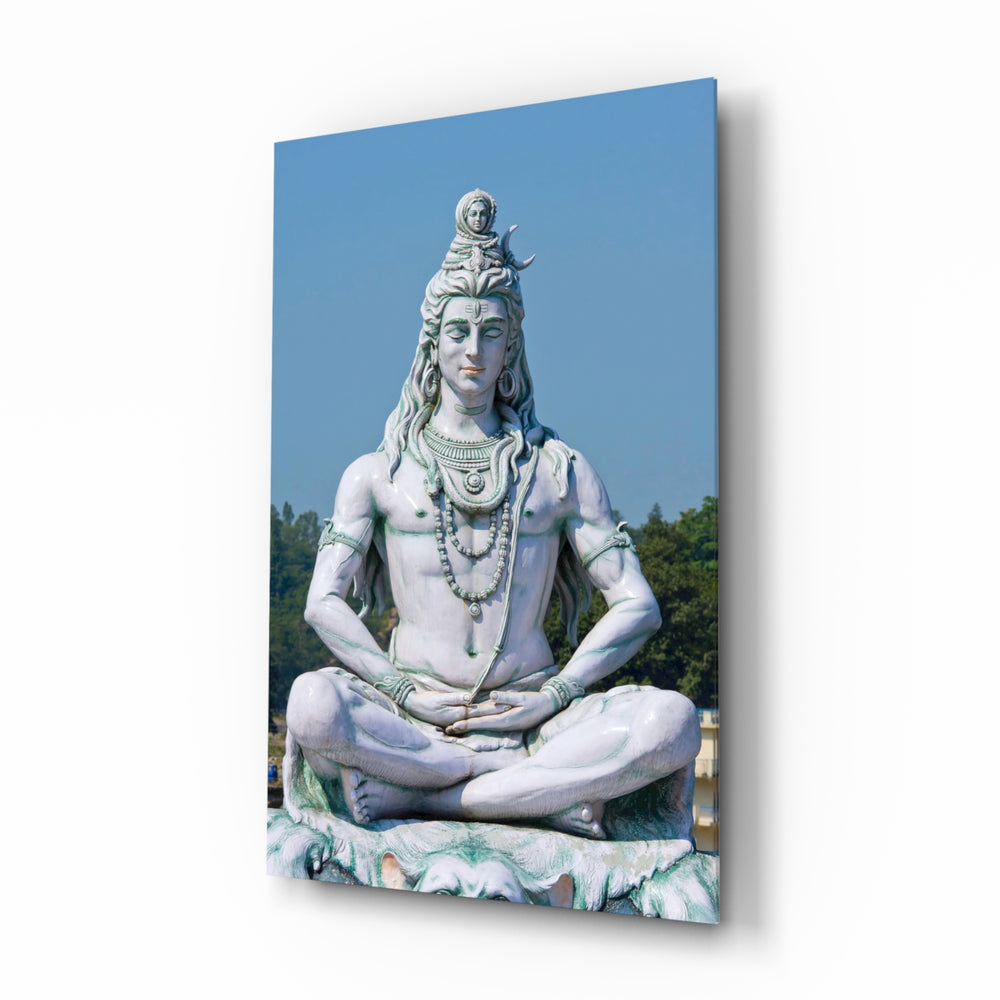 Shiva in Meditation glass wall art displayed above a linen bed in a sage bedroom with rattan nightstands and brushed-brass sconces