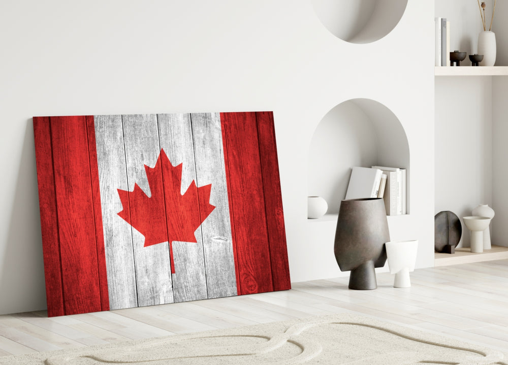 Flag of Canada close-up showing maple leaf on white panel between crimson bands of wood