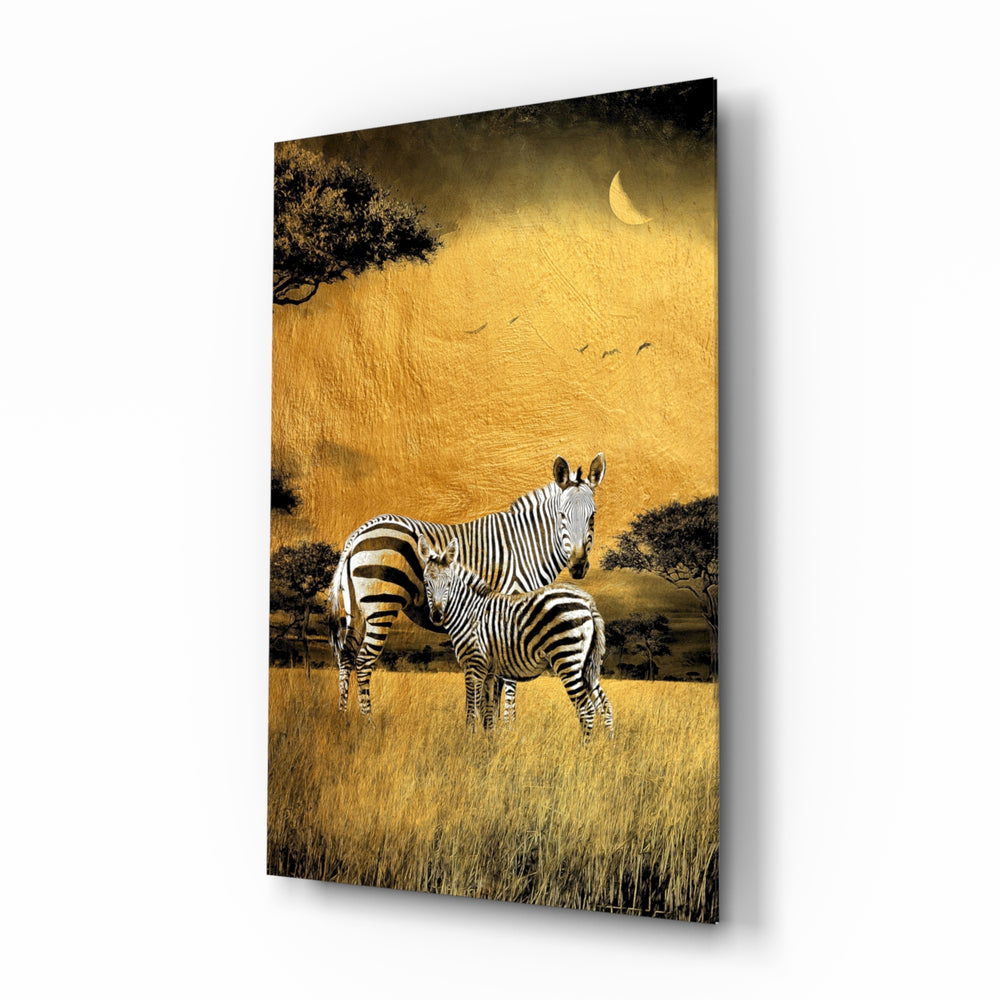 Zebras glass wall art displayed above a linen sofa in a warm safari lounge with rattan armchair and brass picture light