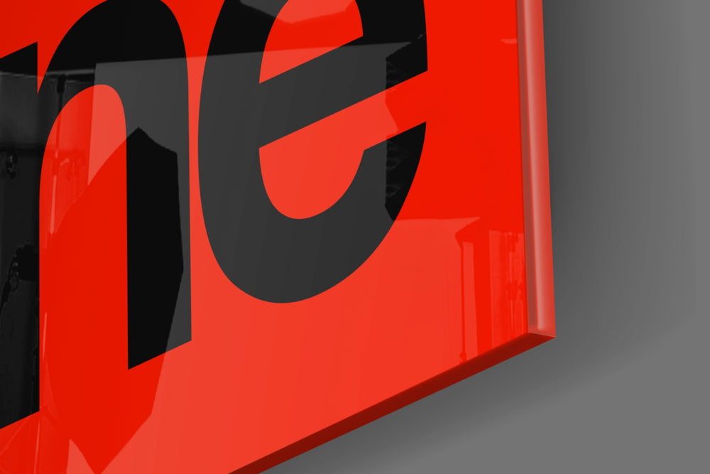Typographic artwork anchoring a desk wall with black-on-crimson palette