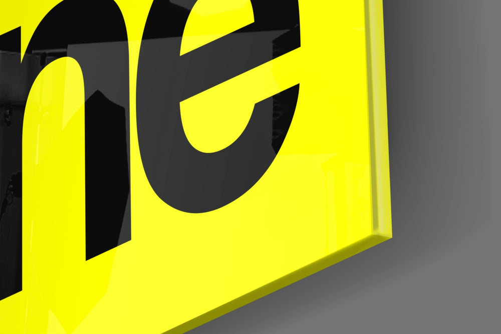 Typographic artwork anchoring a desk wall with black-on-lemon palette