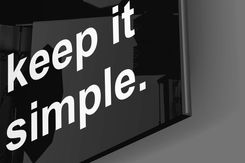 Typography artwork anchoring a wall with obsidian-negative palette